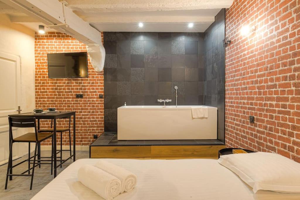 a bathroom with a bath tub and a sink at Industrial-style studio with bathtub, Vieux-Lyon in Lyon