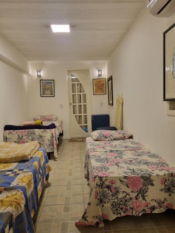 een kamer met drie bedden in een kamer bij Estúdio em Bacaxa in Saquarema