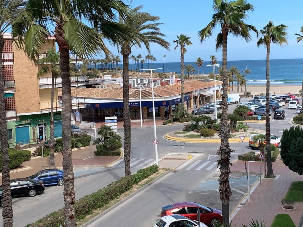 een straat met palmbomen en de oceaan bij Apartamento de 3 habitaciones a 100 m de la playa del Arenal, Javea in Platja de l'Arenal