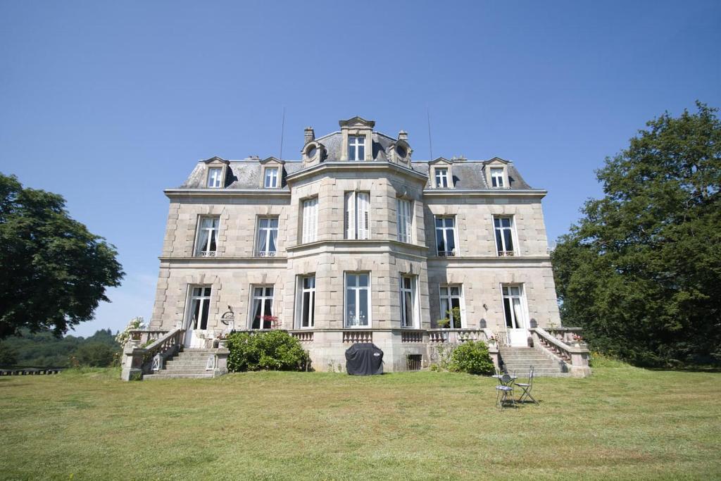 una casa vieja en una colina con césped y escaleras en Chateau les Villettes en Saint-Just-le-Martel