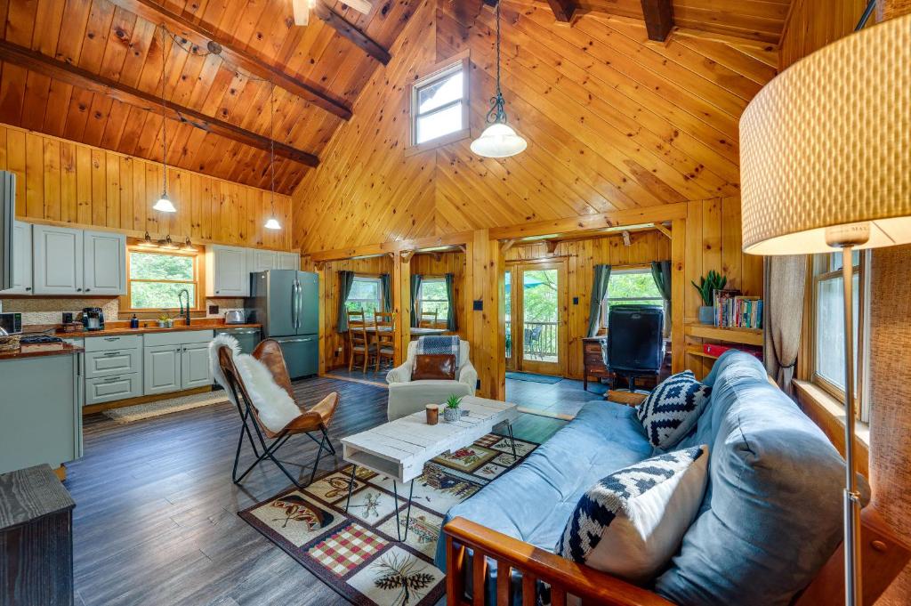 a living room with a blue couch in a cabin at North Haverhill Cabin with Fire Pit and Grill! 