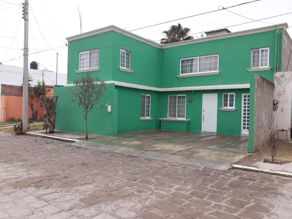 una casa verde sul lato di una strada di Amplios y cómoda cuartos en fraccionamiento privado 