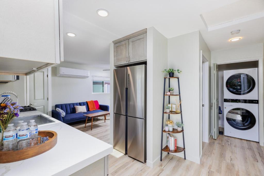 een keuken en een woonkamer met een roestvrijstalen koelkast bij Cozy and Quiet Front House in Fontana