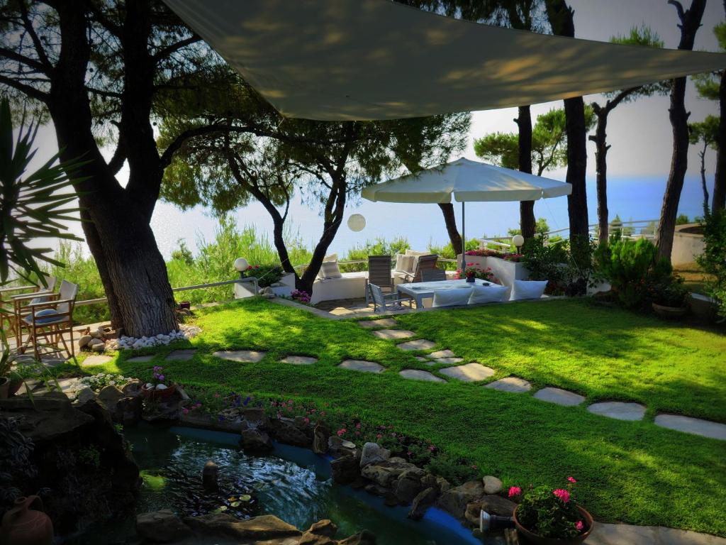 Un patio trasero con un estanque y una mesa y sillas. en BY FAR THE BEST VIEW IN SANI RESORT!, en Sani Beach