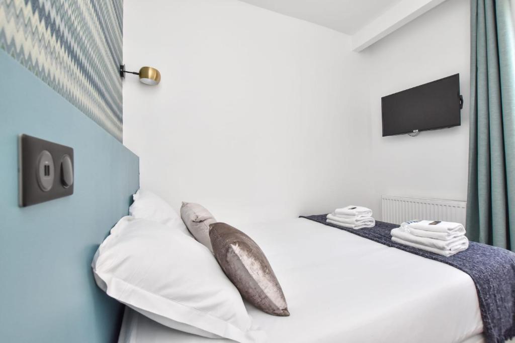 a bedroom with a bed with white sheets and pillows at Résidence Beaugrenelle - Tour Eiffel 1 in Paris