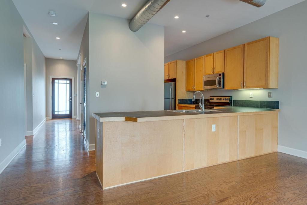 a kitchen with wooden cabinets and a counter top at Historic Edgefield 2bd 2ba Loft in Nashville