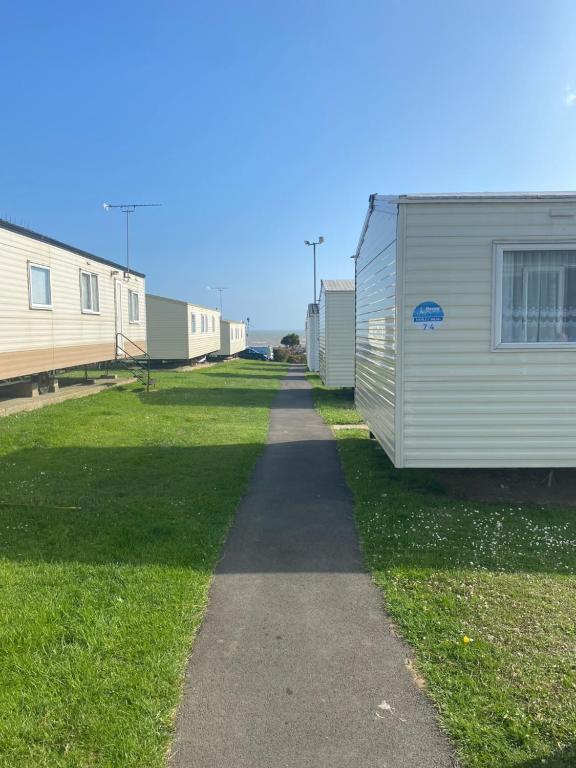 a walkway between two mobile homes in a yard at Combe Haven in Hastings