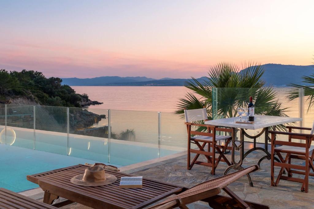 a patio with a table and chairs next to a pool at Arte Suites Pefki in Pefki Rhodes