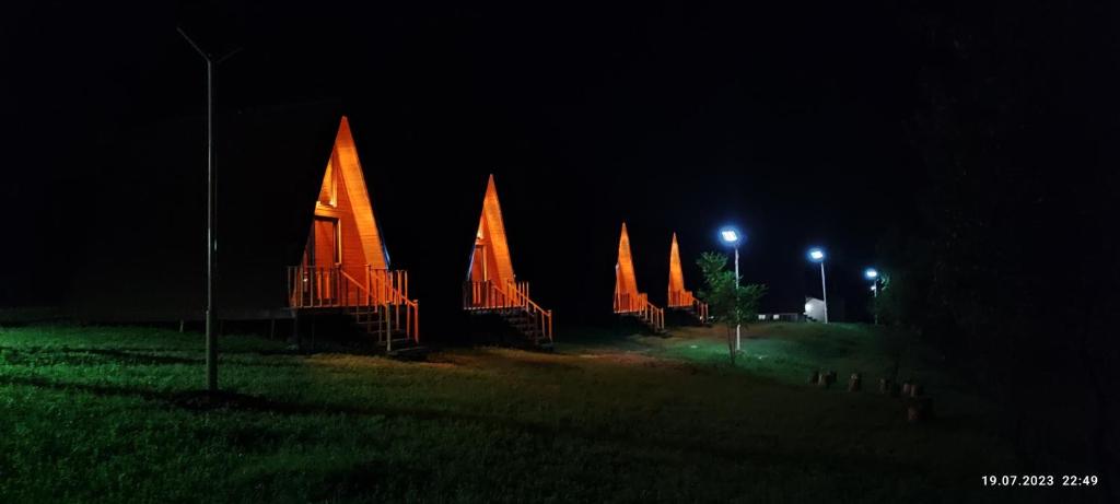 a group of orange structures lit up at night at Aquacool in Crasna