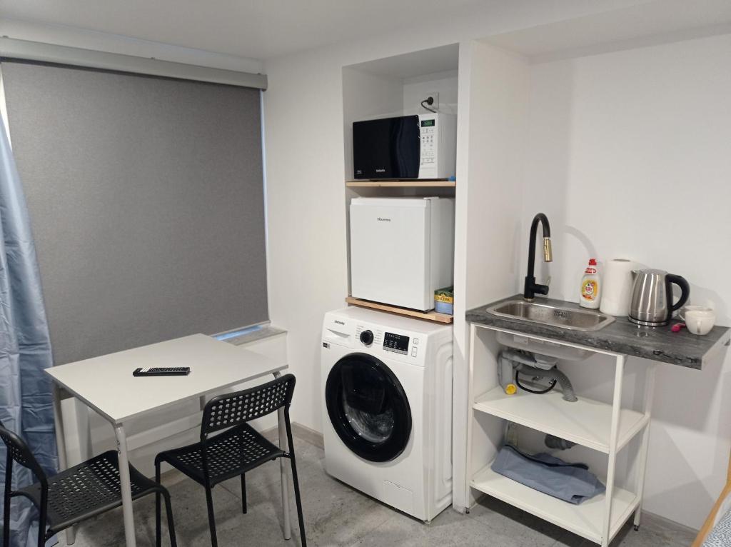 a laundry room with a washing machine and a table at Apartment hotels parking akaciju1 in Vilnius