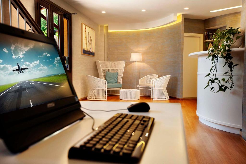 un computer portatile seduto su una scrivania con tastiera di FAVIGNANA HOTEL Concept Holiday a Favignana