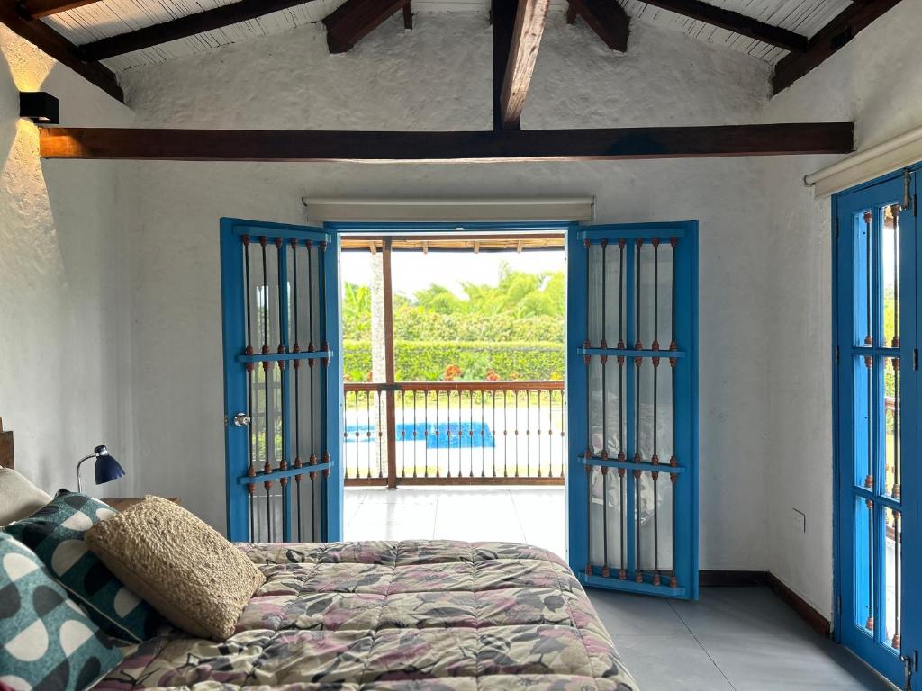 una camera con porte blu e un letto in una stanza di Casa El Tesorito a La Tebaida