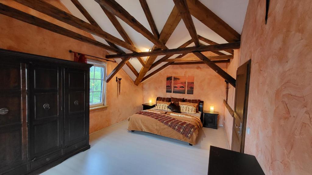 a bedroom with a bed in a room with wooden ceilings at Apartments am Saalebogen mit Gartenterrasse & Grillkamin, freie Parkplätze in Rudolstadt