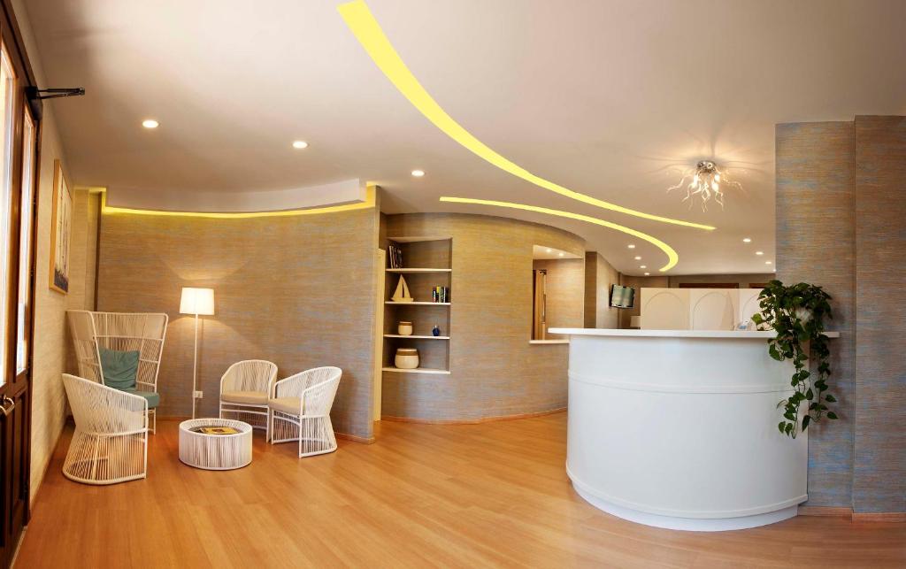 a lobby with chairs and a counter in a building at FAVIGNANA HOTEL Concept Holiday in Favignana