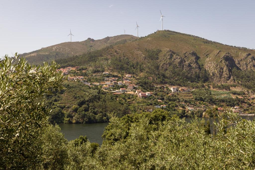 eine Stadt auf einem Hügel mit einem Fluss in der Unterkunft Casas de Xisto in Raiva