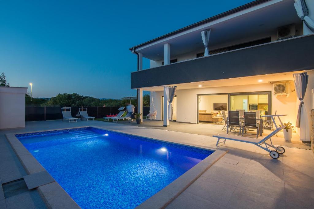 a swimming pool in the backyard of a house at Apartment Aurora Island Krk Malinska in Sveti Anton