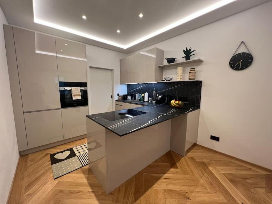 uma cozinha com um balcão preto num quarto em Central Luxury Apartment em Linz