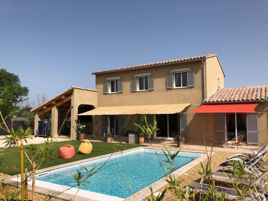 una casa con piscina frente a una casa en Superbe villa neuve à 5 mn du centre en Saint-Rémy-de-Provence