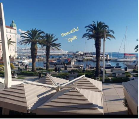 a view of a marina with palm trees and umbrellas at Apartment Butterfly Split - for rest and relaxation in Split