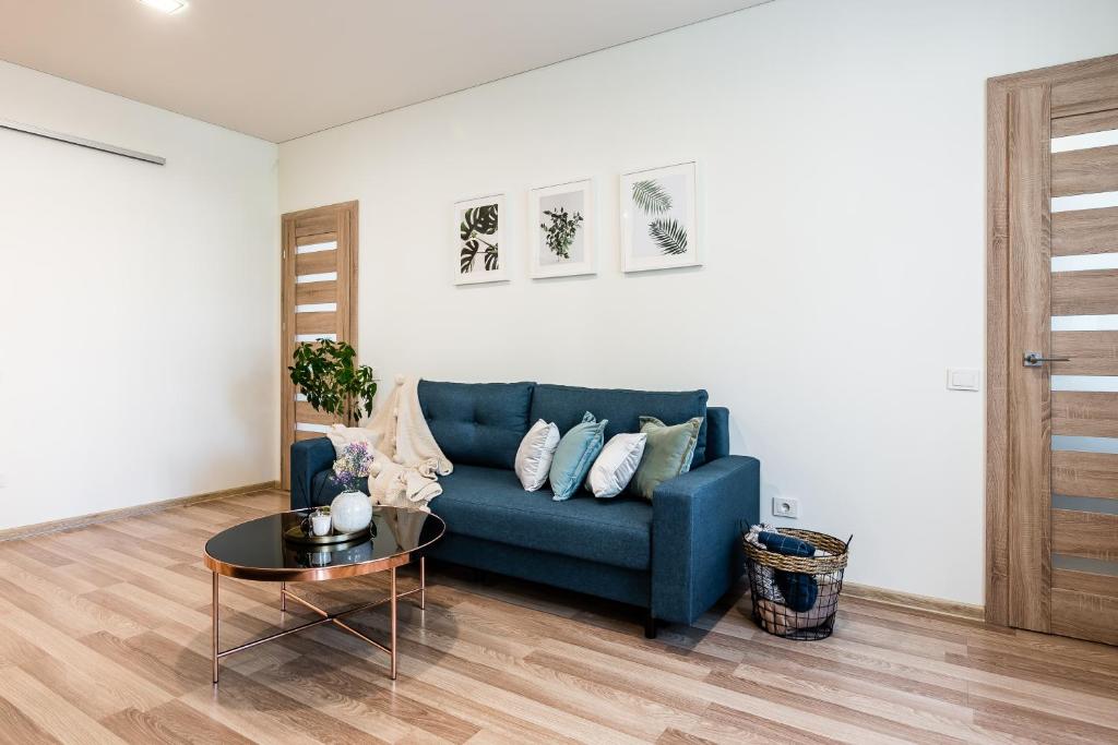 a living room with a blue couch and a table at Karaliaus apartment in Kaunas