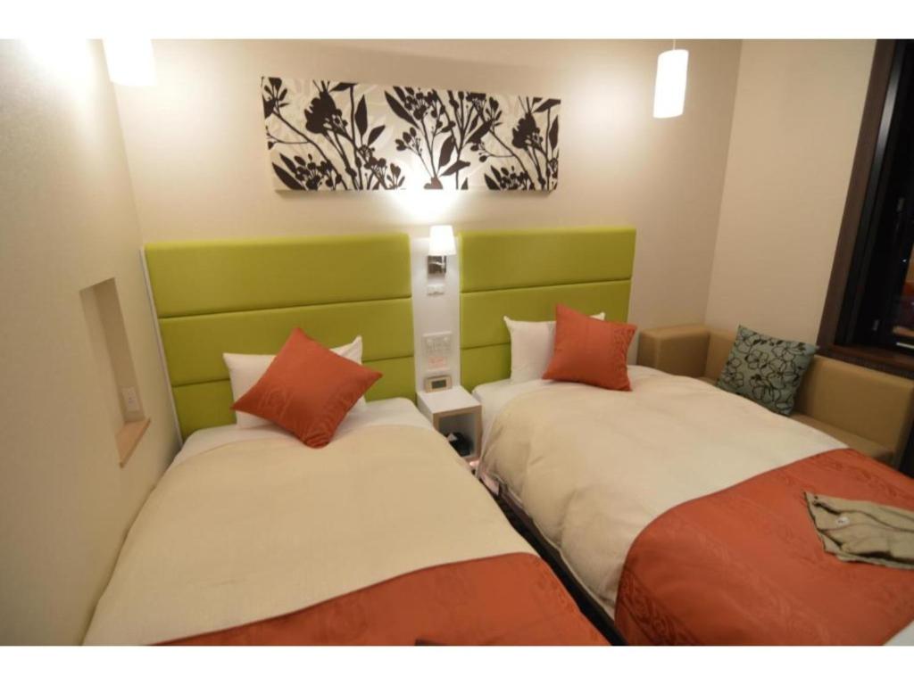 two beds sitting next to each other in a room at QUEEN'S HOTEL CHITOSE - Vacation STAY 67738v in Chitose