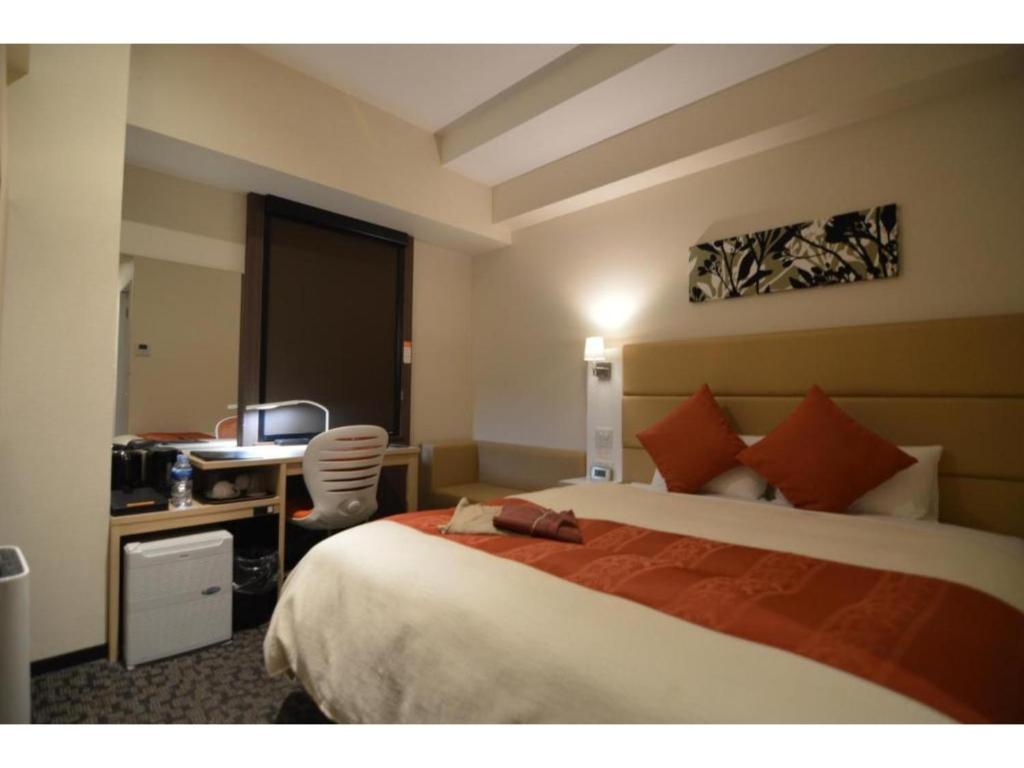 a hotel room with a bed and a desk at QUEEN'S HOTEL CHITOSE - Vacation STAY 67719v in Chitose