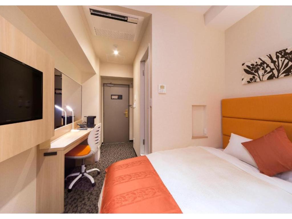 QUEEN'S HOTEL CHITOSE - Vacation STAY 67732v في تشيتوسي: غرفة فندقية فيها سرير ومكتب وتلفزيون