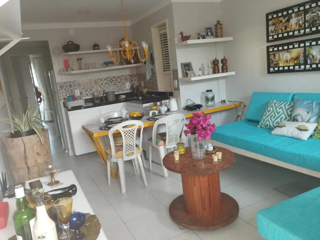 Flat Villagio Coqueiro في لويس كوريا: غرفة معيشة مع أريكة زرقاء وطاولة