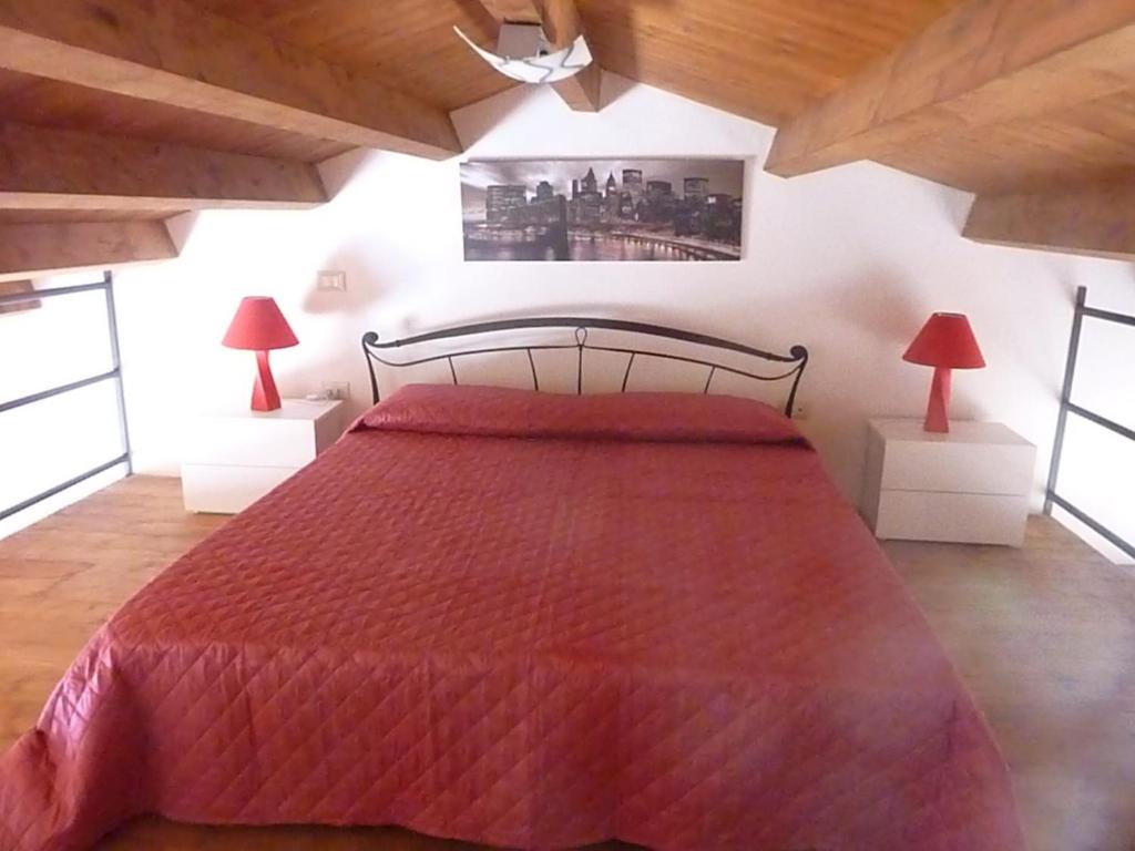 パレルモにあるMAMA'S HOMEのベッドルーム1室(赤い大型ベッド1台、ランプ2つ付)