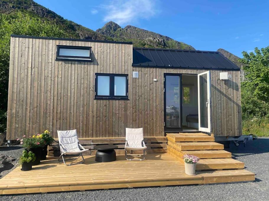 a tiny house with a deck and two chairs at Moderne minihus ved havet in Sørvågen