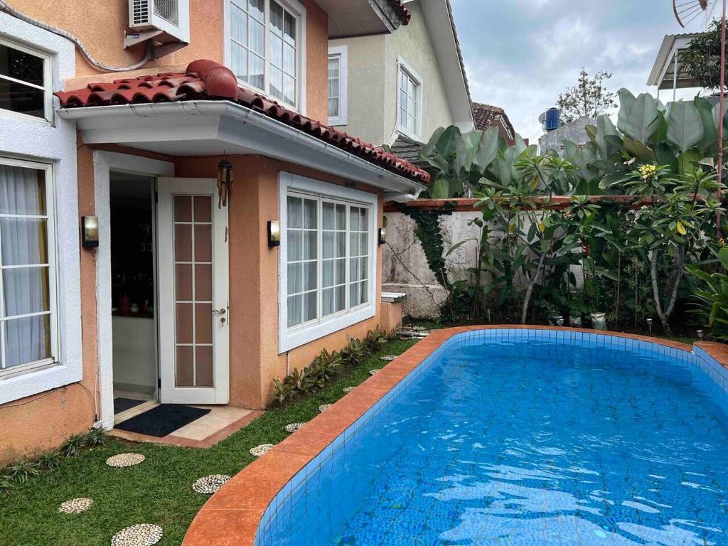 a swimming pool in front of a house at Private Villa with Swimming Pool in Babakan Madang