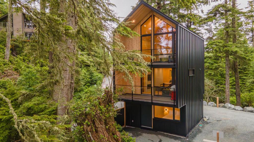 a house in the woods with black exterior at The Cabins at Terrace Beach in Ucluelet