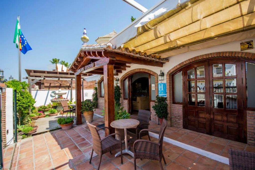 a patio with a table and chairs and a building at Hotel Casa Grande in Zahara de los Atunes