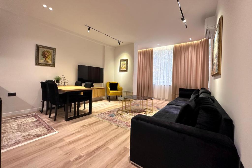 a living room with a couch and a dining room at Exquisite by Broci Apartments in Tirana