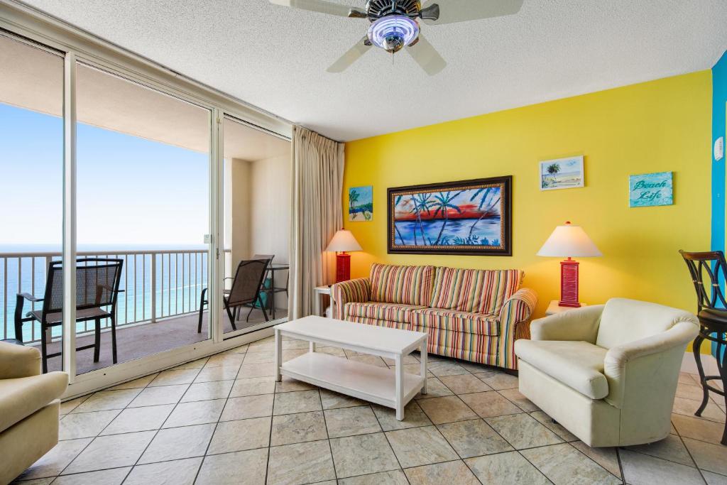 a living room with a couch and chairs and a balcony at Majestic Beach Towers 2013 in Panama City Beach