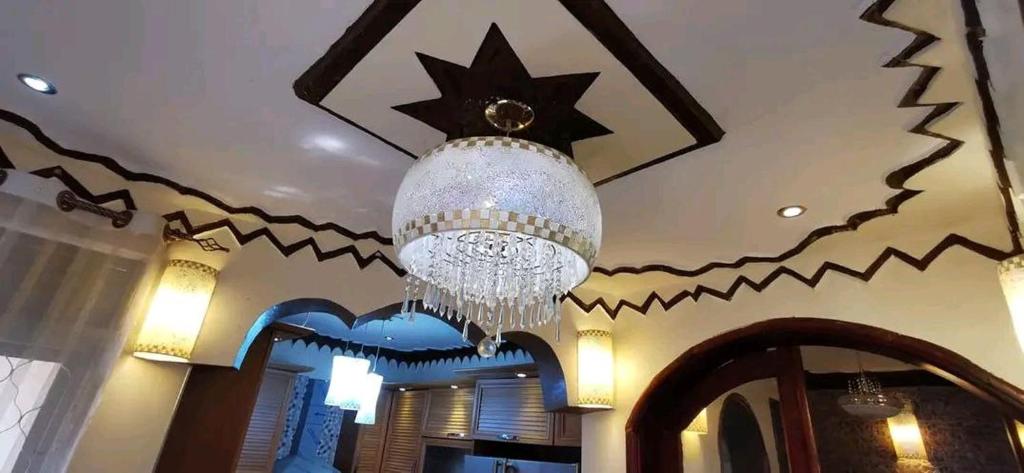 lampadario pendente appeso a un soffitto in una stanza di Albert Suites & Apartments Entebbe a Entebbe