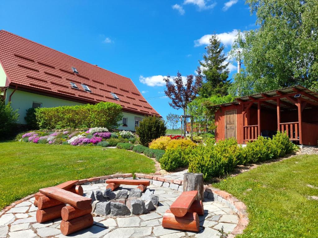 einen Garten mit einer Feuerstelle und einem Gebäude in der Unterkunft Apartmány Brychovi in Červený Potok