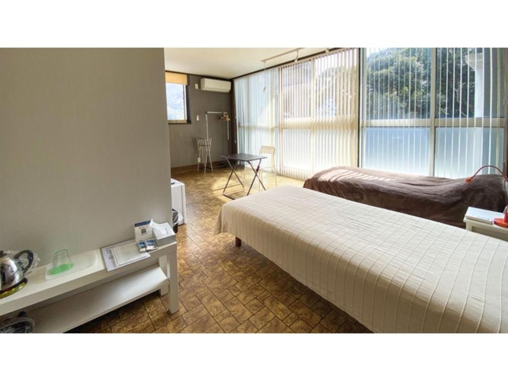 um quarto de hotel com duas camas e uma varanda em Forte "Hachijojima" - Vacation STAY 62454v em Hachijo