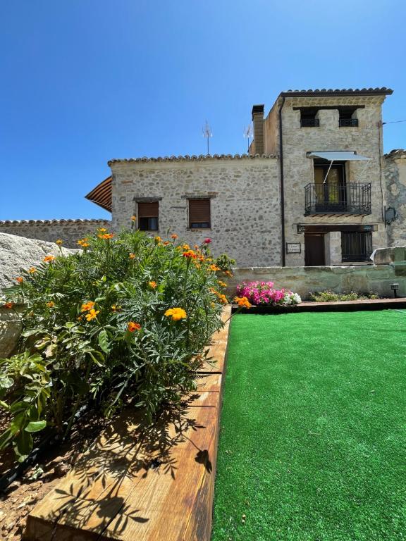 un jardín con flores frente a un edificio en Casa Carabias, en Carabias