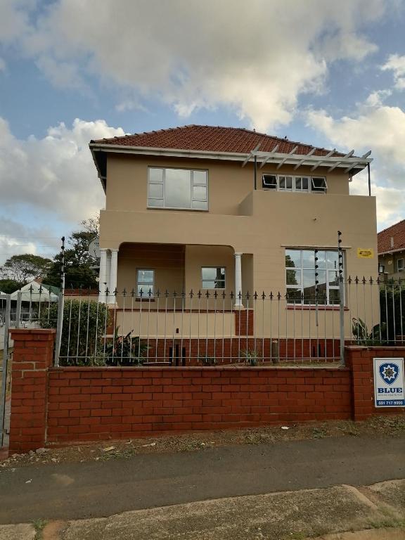 une maison avec une clôture devant elle dans l'établissement Glenwood, à Durban