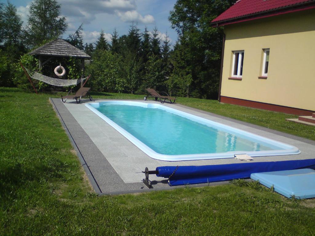 a swimming pool in a yard with a gazebo at Gospodarstwo Agroturystyczne Wólka 34 in Filipów