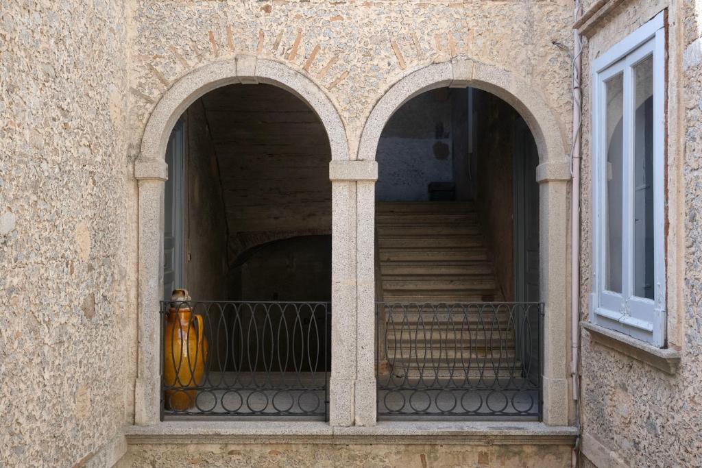 einen Eingang zu einem Gebäude mit zwei Bögen und Treppen in der Unterkunft Palazzo Falletti in Guardavalle
