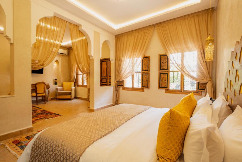 1 dormitorio con 1 cama blanca grande con almohadas amarillas en Le Palais Averroes - Adults Only en Marrakech