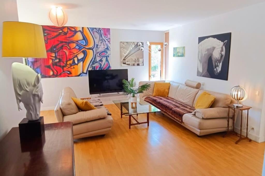 a living room with a couch and a tv at Les Villas de Beaulieu in Caen