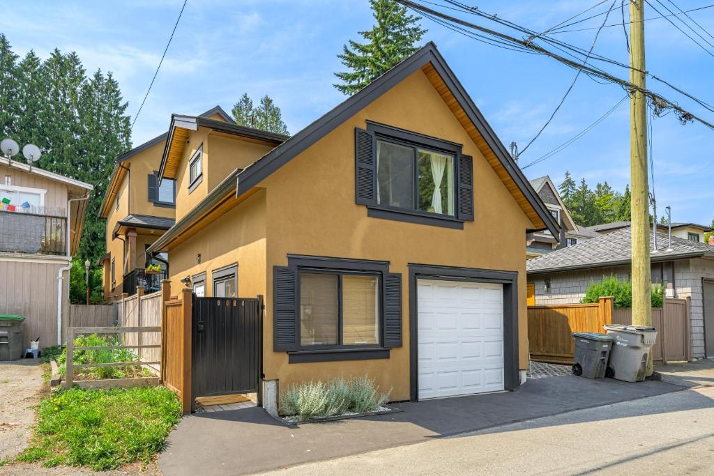 a yellow house with a white garage at Minimal - 30 nights minimum in Vancouver