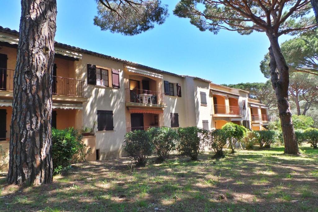 un grand bâtiment avec des arbres devant dans l'établissement Le CASTILLON A 10, aux Issambres