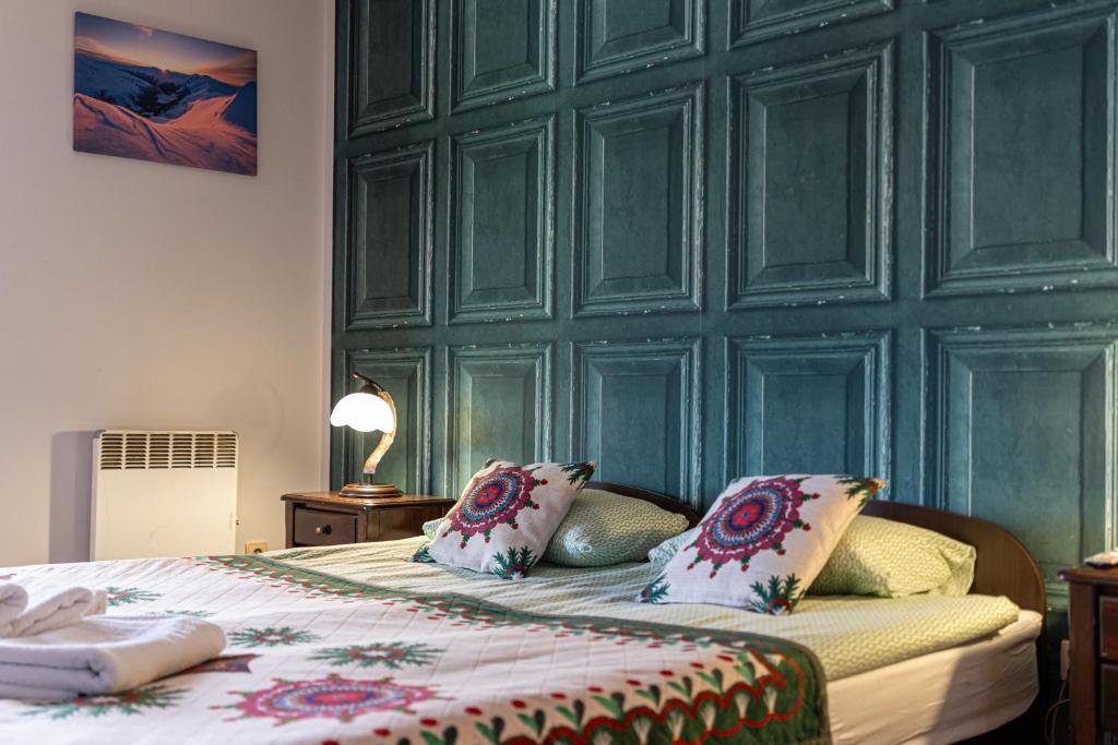 sypialnia z zieloną ścianą i łóżkiem z poduszkami w obiekcie Apartamenty Parzenica w Zakopanem