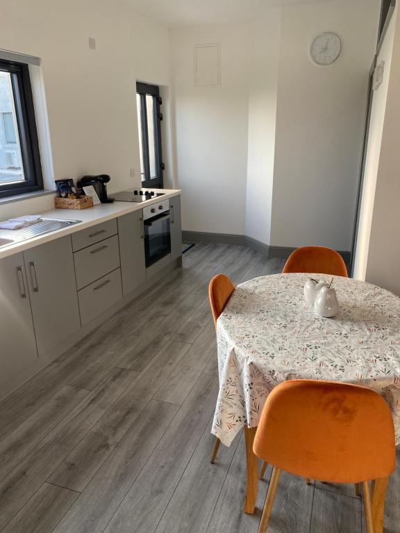 a kitchen with a table and two chairs and a table and a table and chairs at Hill Top View Apartment Lahinch in Lahinch