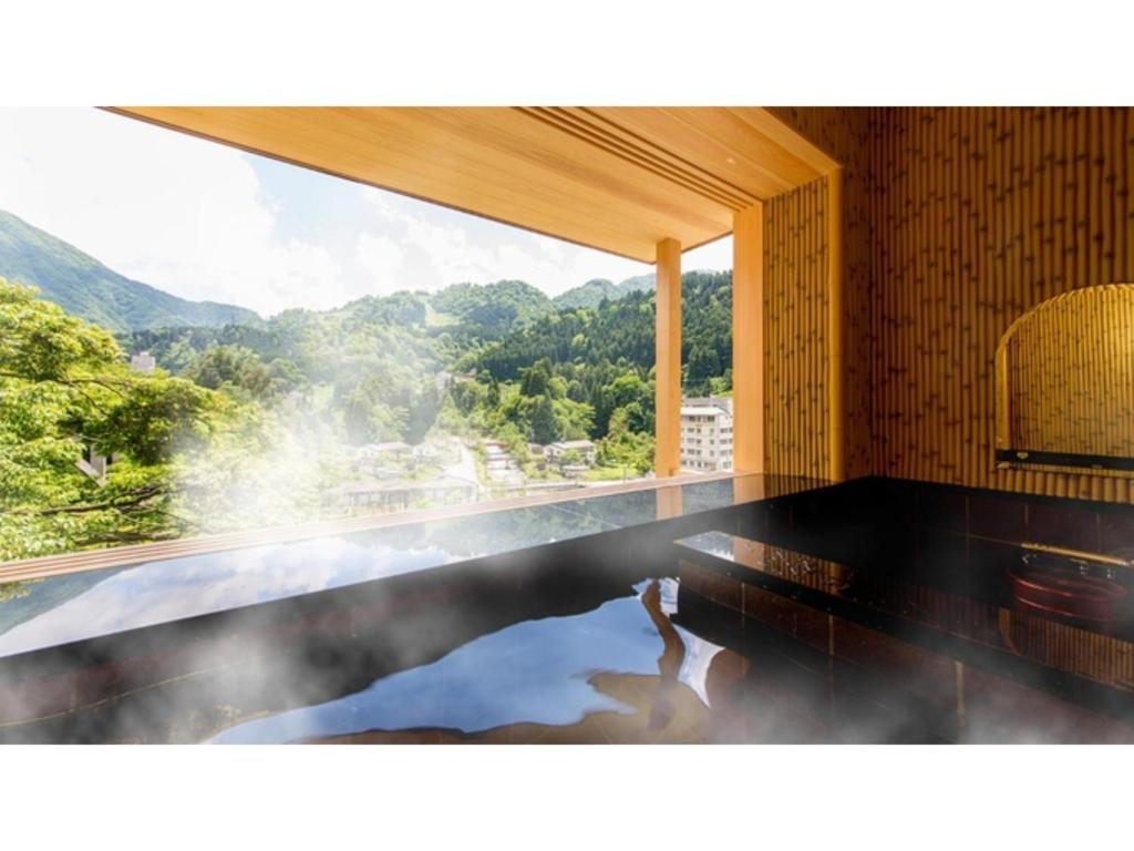 um quarto com uma piscina com vista para uma montanha em Unazuki Onsen Sanyanagitei - Vacation STAY 06440v em Kurobe