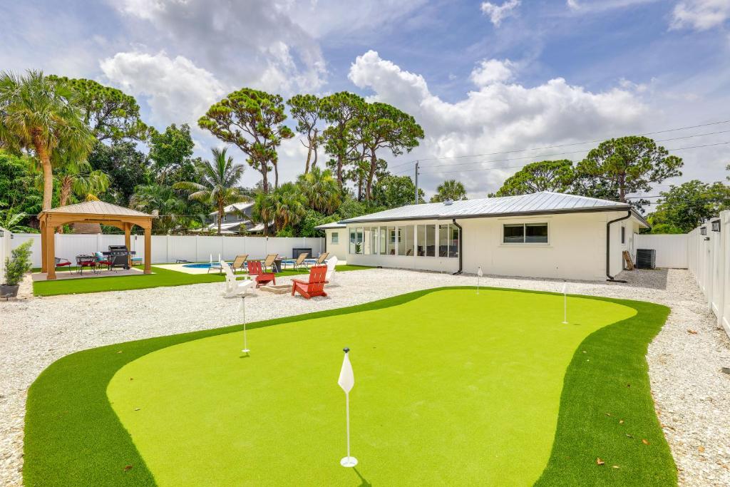 a house with a green yard with a putting green at Vero Beach Vacation Rental Pool and Putting Green! in Vero Beach